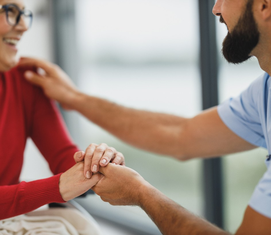 A Medice clinician sitting with a patient, holding her hands