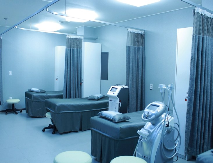 A treatment bay with three curtained beds and monitoring equipment